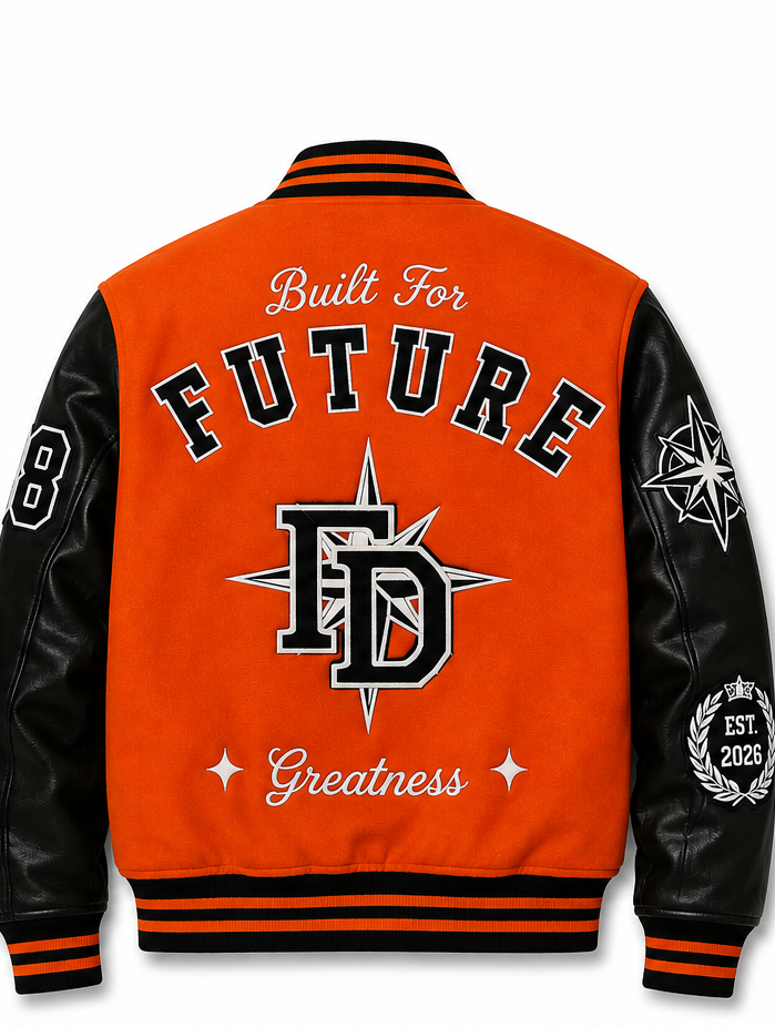 The back of a varsity-style jacket with a bright orange body and black sleeves, featuring collegiate lettering that reads 'Built For FUTURE Greatness' and a large 'FD' emblem with a compass star.