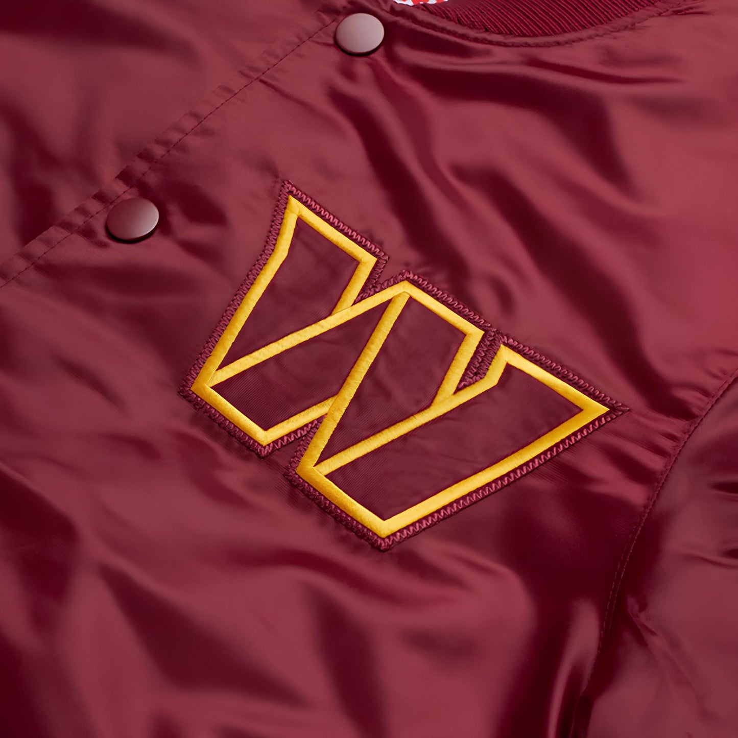 Close-up of a maroon jacket with a "W"  logo on a matching background