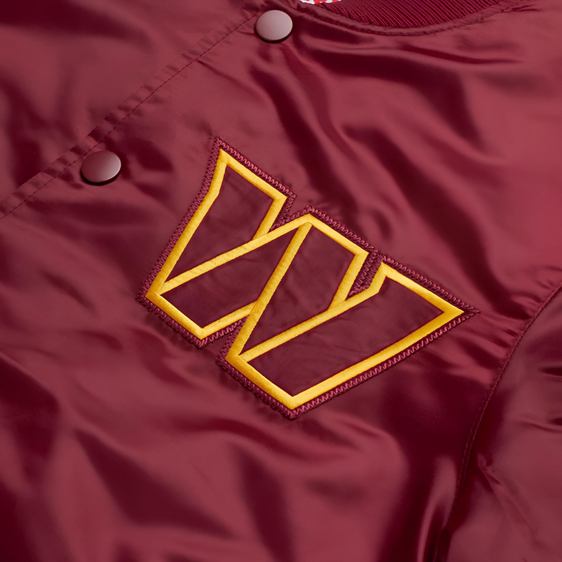 Close-up of a maroon jacket with a "W"  logo on a matching background