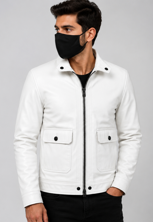 A man wearing a white leather jacket with a black zipper, snap-button flap pockets, and a black face mask, standing against a light gray studio background.