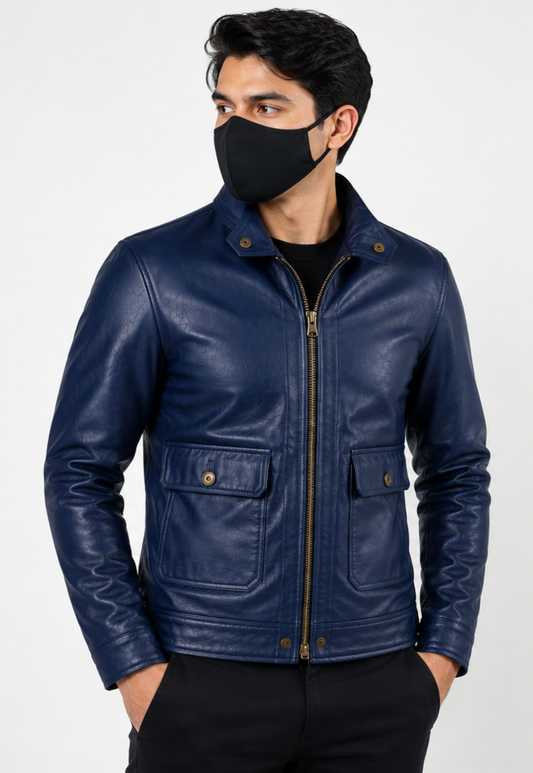 A man wearing a navy blue leather jacket with a front zipper, snap-button flap pockets, and gold-tone hardware, paired with a black face mask and black pants, against a light gray studio background.