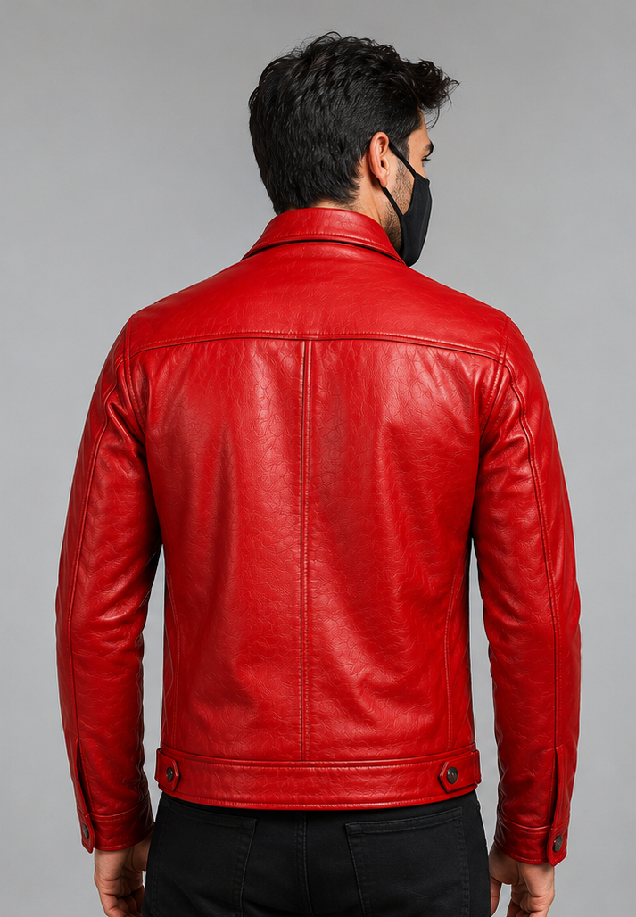 A man viewed from the back wearing a bright red leather jacket and a black face mask, standing against a plain light gray studio background.