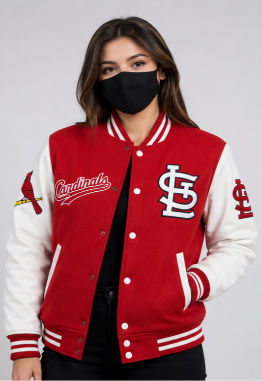 A woman wearing a red and white St. Louis Cardinals varsity jacket with a black face mask, shown against a light gray studio background.