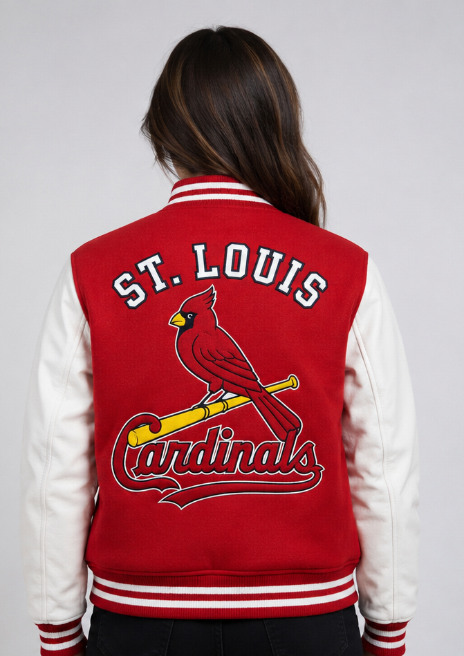 A woman viewed from behind wearing a red and white St. Louis Cardinals varsity jacket with a large embroidered bird and bat logo on the back.
