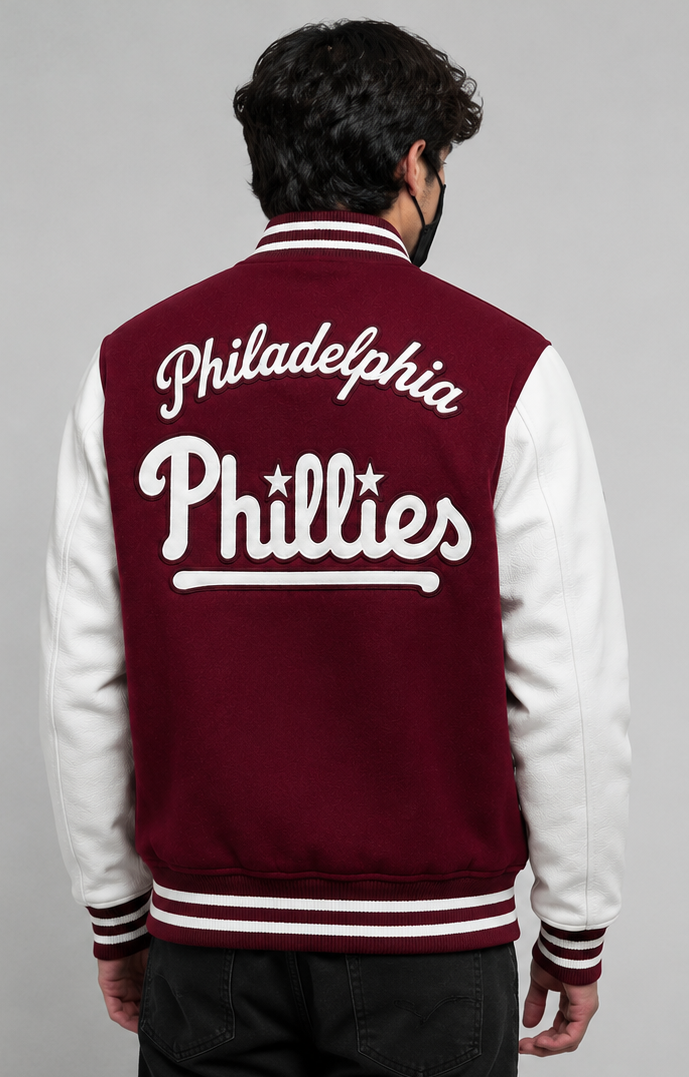 A man viewed from behind wearing a Philadelphia Phillies varsity jacket. The jacket has a maroon body with white sleeves and white lettering on the back.
