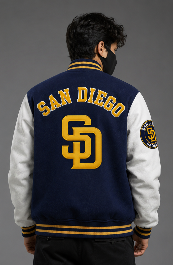 A man wearing a navy and white varsity jacket with 'SAN DIEGO' and 'SD' lettering on the back, shown from behind against a gray studio background.