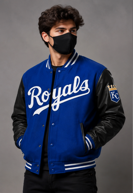 A man wearing a royal blue and black varsity jacket with 'Royals' written in white script on the chest posed against a neutral gray studio background.