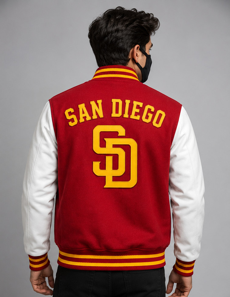 A man viewed from behind wearing a red and white varsity jacket with 'SAN DIEGO' and the 'SD' logo embroidered in yellow on the back, set against a plain gray studio background.