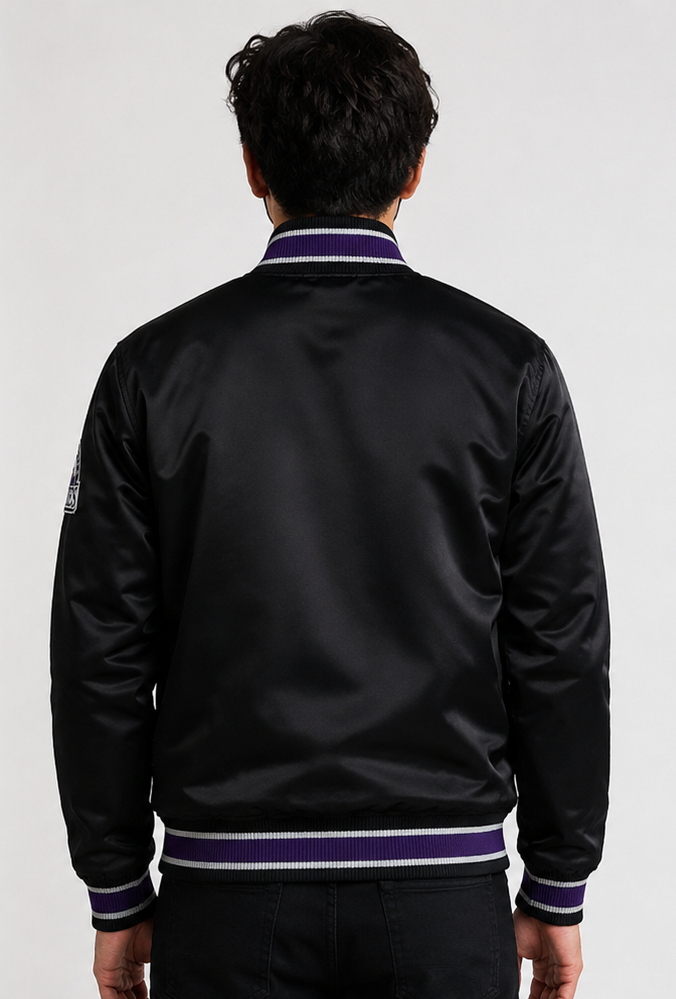 A man viewed from behind wearing a black satin bomber jacket with purple and white striped ribbed trim on the collar, cuffs, and hem.