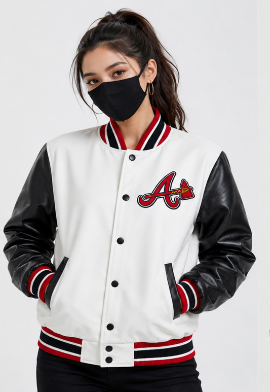 A woman wearing a white fleece varsity-style jacket with black faux-leather sleeves and red, black, and white striped ribbed trim. The jacket features a large red and black Atlanta Braves 'A' logo on the left chest.