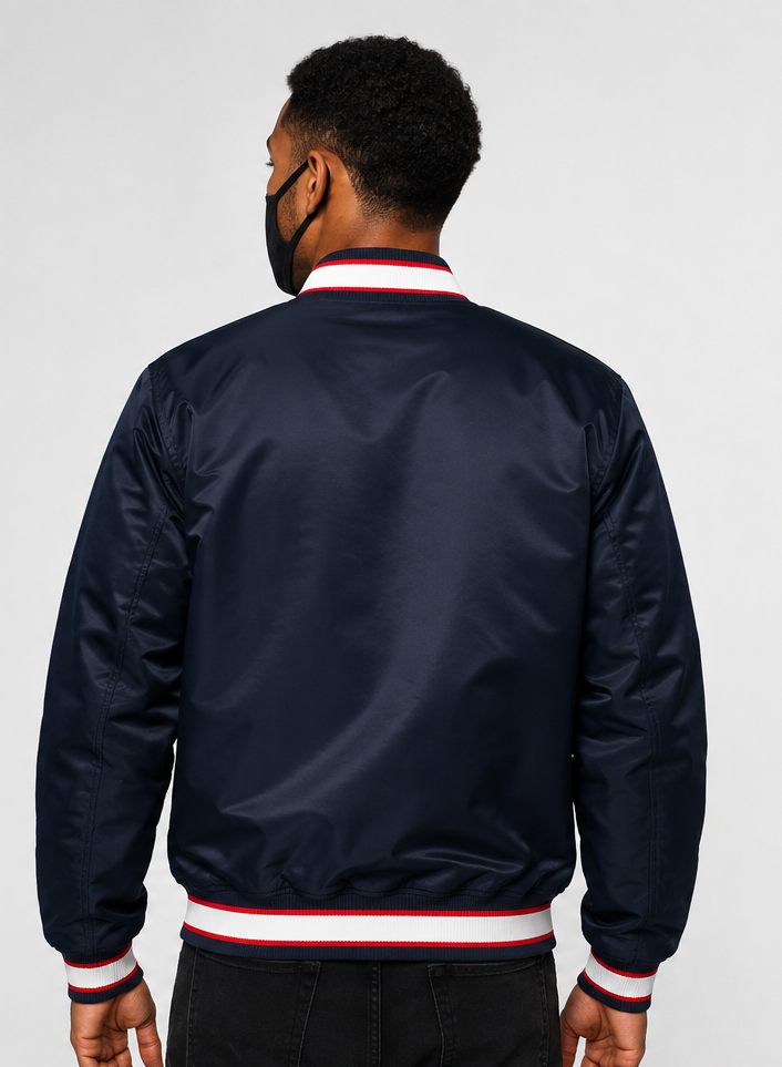 A man was viewed from the MLB Minnesota Twins Navy Blue Satin Bomber Jacket for Men & Woment a light gray studio background.