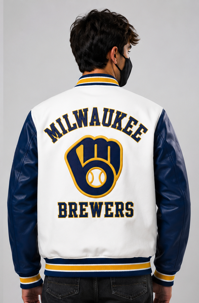 A man viewed from behind wearing a Milwaukee Brewers varsity jacket with navy blue leather sleeves, a white body, and yellow and navy blue trim and lettering.