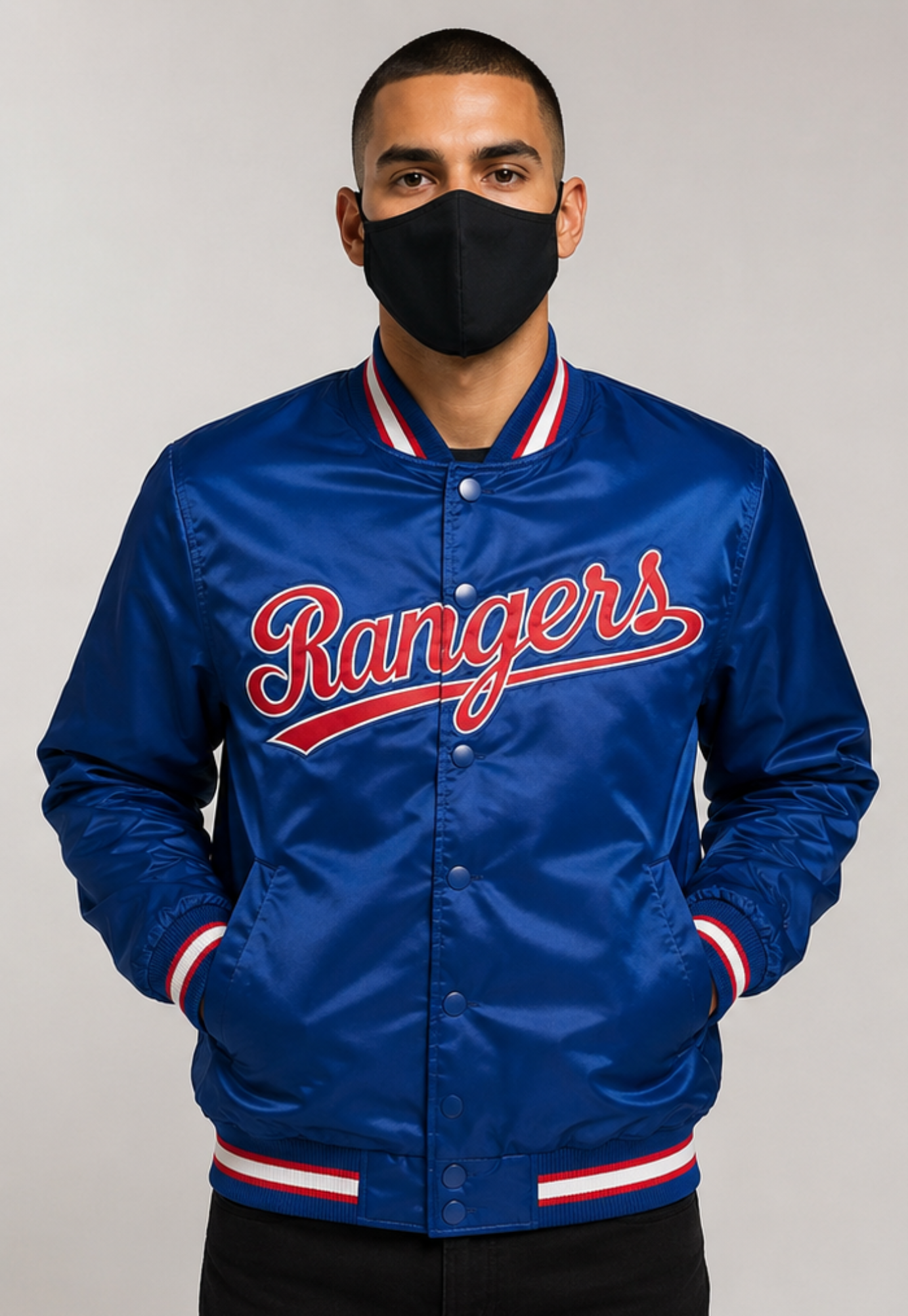 A man wearing a royal blue satin varsity jacket with 'Rangers' written in red script across the chest, paired with a black face mask, set against a plain light gray background.