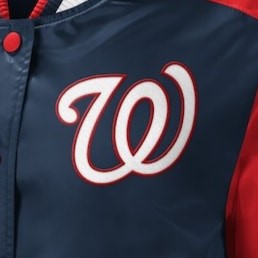 Close-up of a navy blue baseball jacket with a large white script 'W' outlined in red on the chest, plus red side panels and a red button.