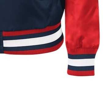 Close-up of a satin bomber jacket showing the navy blue body, red sleeve, and striped ribbed trim in navy, white, and red.
