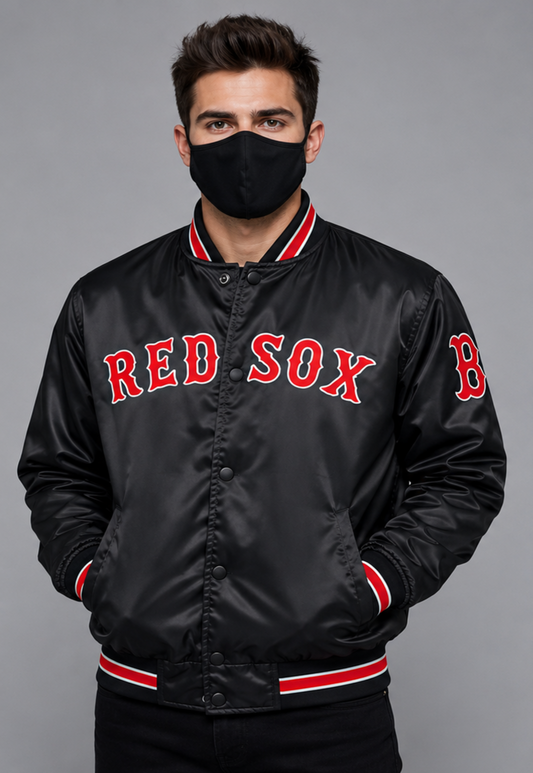 A man wearing a black satin Boston Red Sox bomber jacket with red and white trim, featuring 'RED SOX' in red arched letters on the chest, posed against a solid gray background.