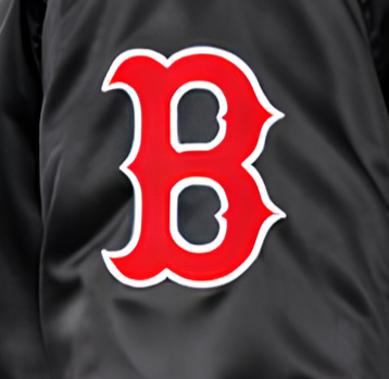 Close-up of a black satin or shiny fabric surface with a large red letter B outlined in white, resembling a Boston Red Sox style logo.