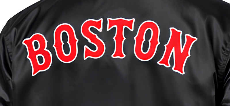Close-up of the back of a black satin or nylon jacket with the word 'BOSTON' in large red letters outlined in white across the upper back.