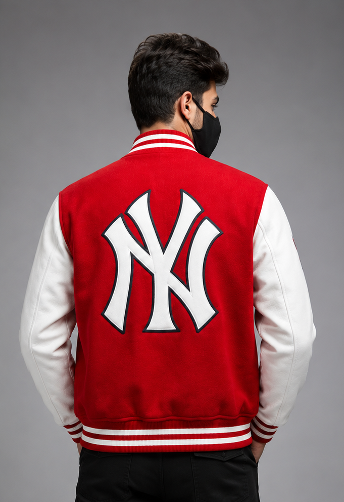 A man viewed from behind wearing a red and white varsity jacket with a large white New York Yankees 'NY' logo on the back, set against a solid gray studio background.