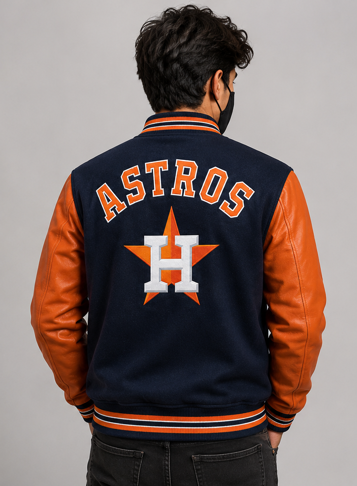 A man viewed from behind wearing a Houston Astros varsity jacket with a navy blue body, orange leather sleeves, and 'ASTROS' lettering with the team logo on the back.