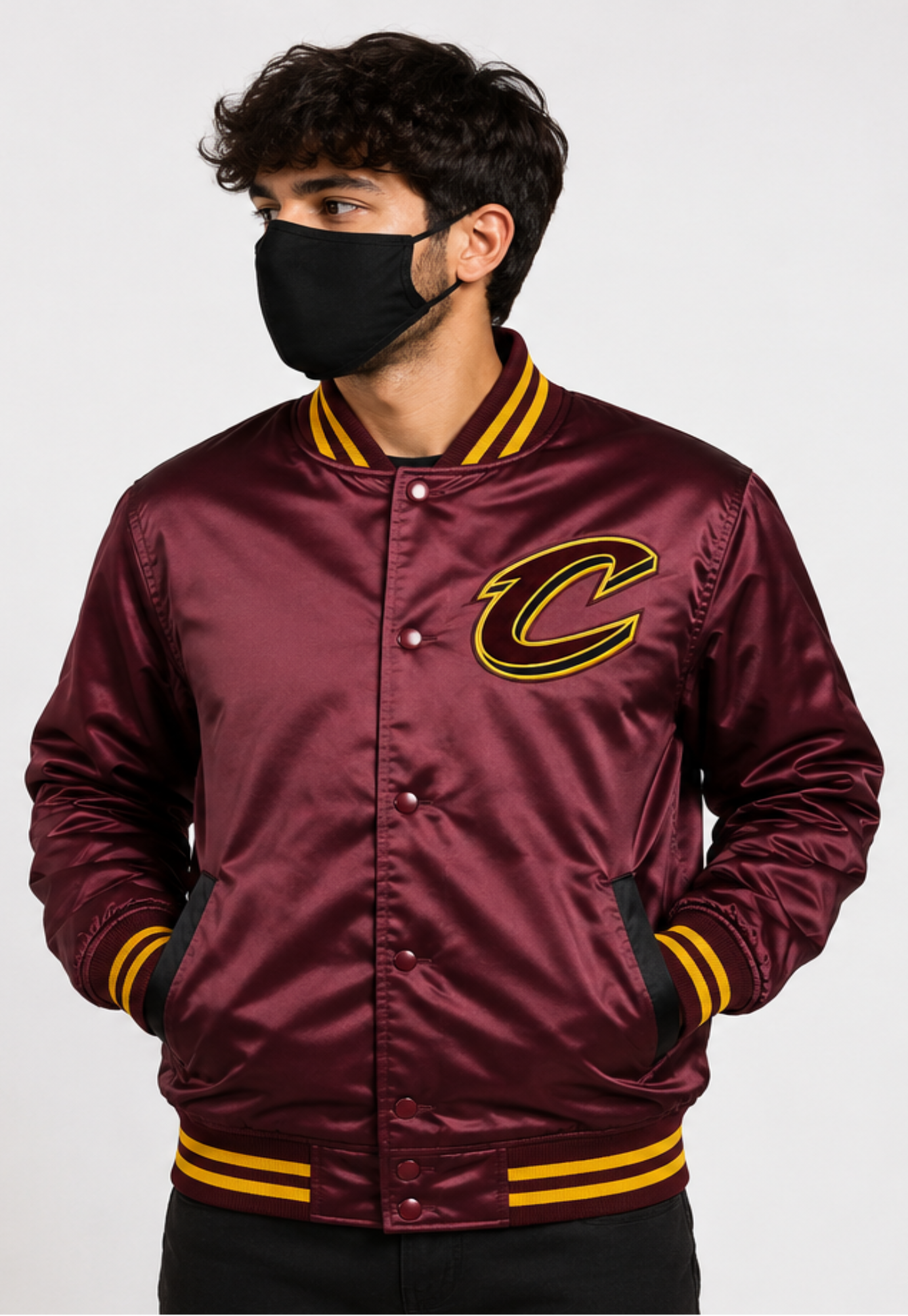 A man wearing a shiny maroon satin varsity jacket with yellow and black striped ribbed trim and a large embroidered 'C' logo on the chest, paired with a black face mask against a light gray background.