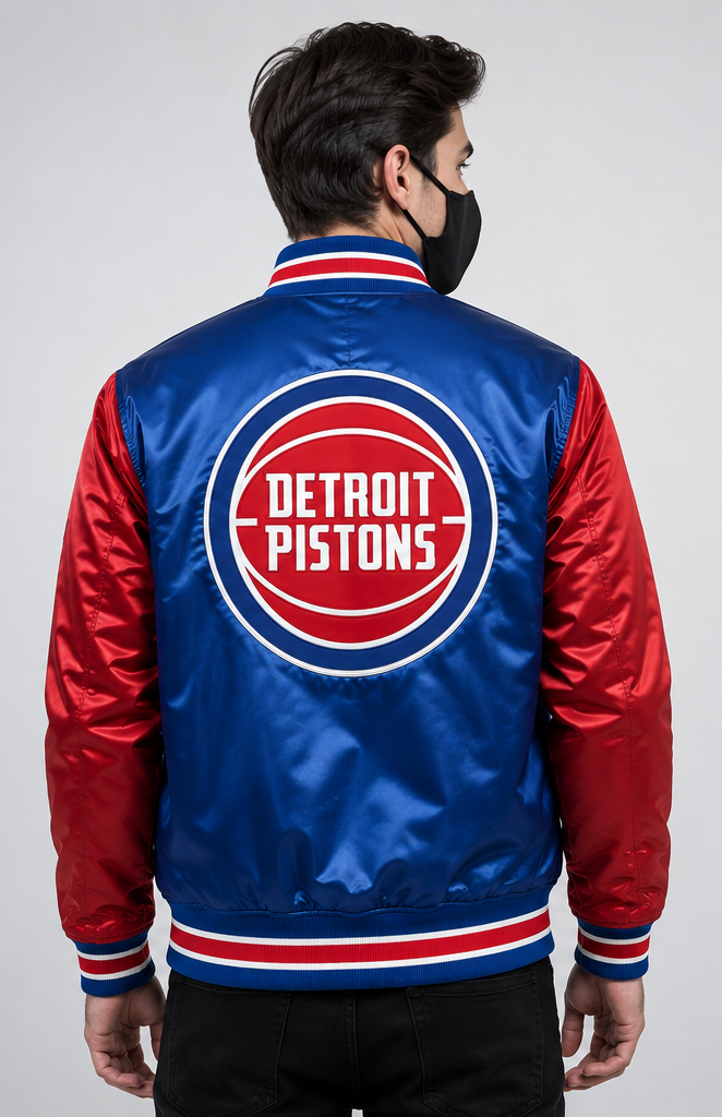 A man viewed from the back wearing a Detroit Pistons satin bomber jacket with a red and blue body, red sleeves, and a large circular team logo on the back.