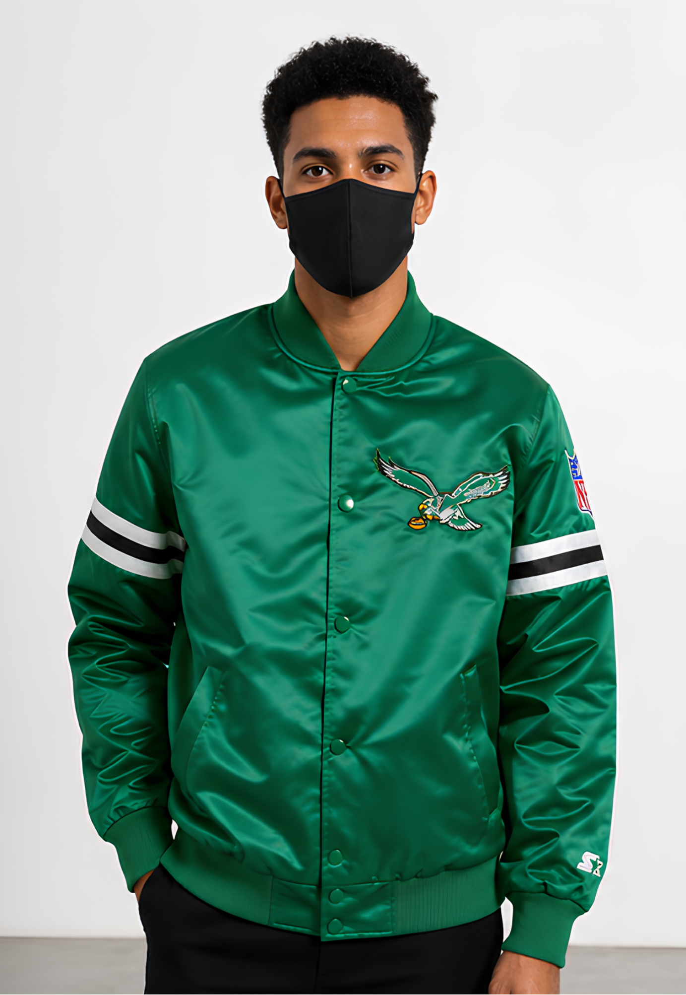 Person wearing a Philadelphia Eagles green satin jacket with a logo on a white background