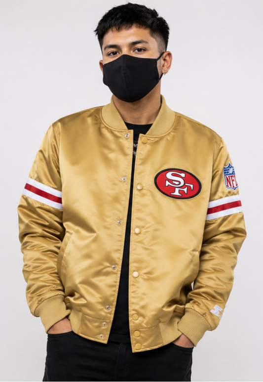 Person wearing a San Francisco 49ers gold jacket with a sports team logo on a white background