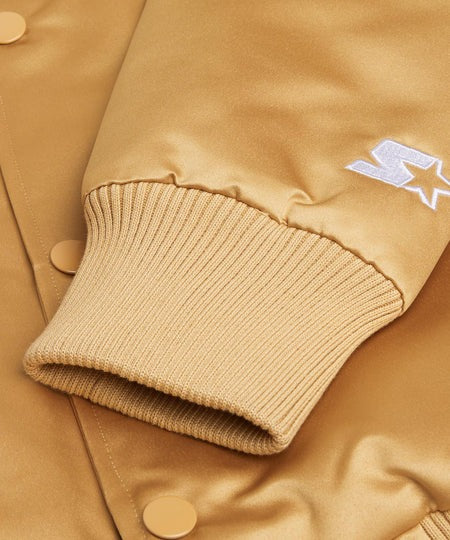 Close-up of a tan jacket with a brand logo on the sleeve