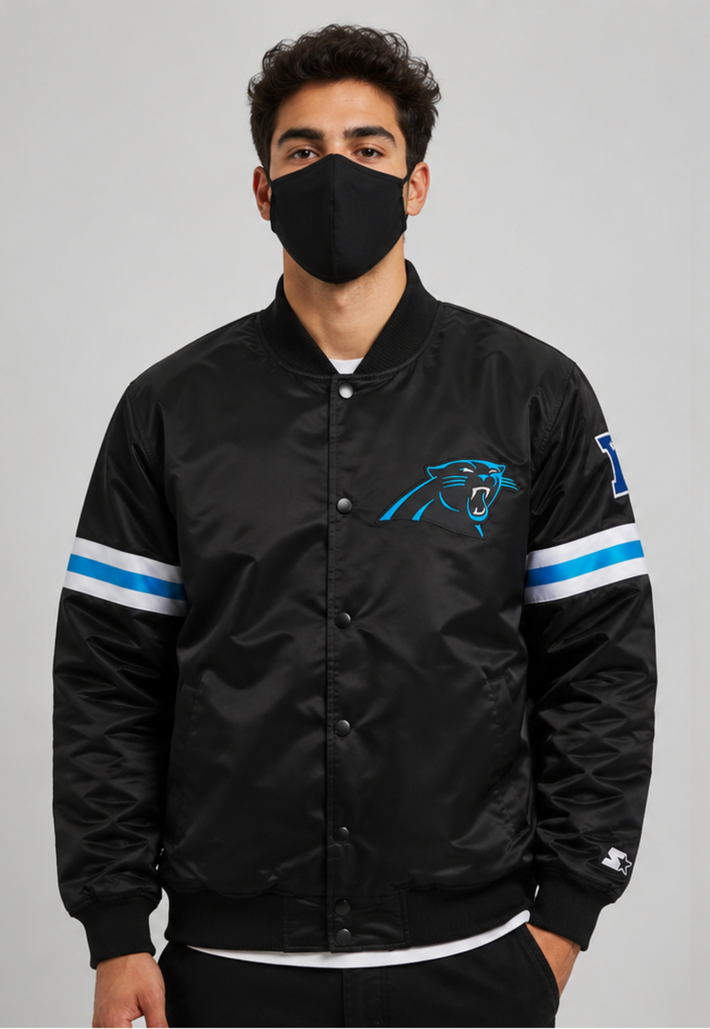 Person wearing a Carolina Panthers black sports jacket with logos on a gray background