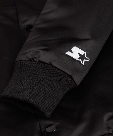 Close-up of a black jacket with a white logo on a dark background