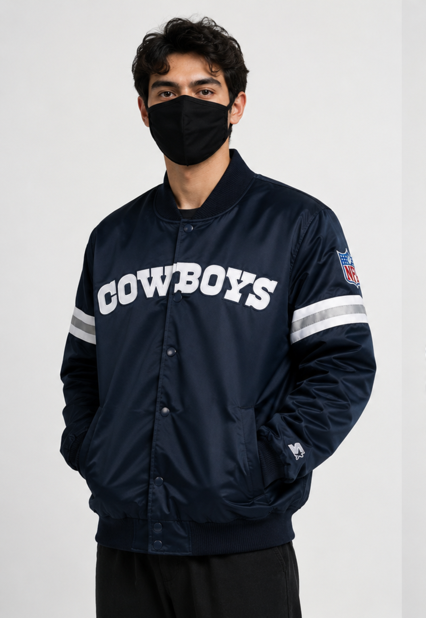 Person wearing a Dallas Cowboys navy blue 'Cowboys' jacket with white lettering on a light gray background