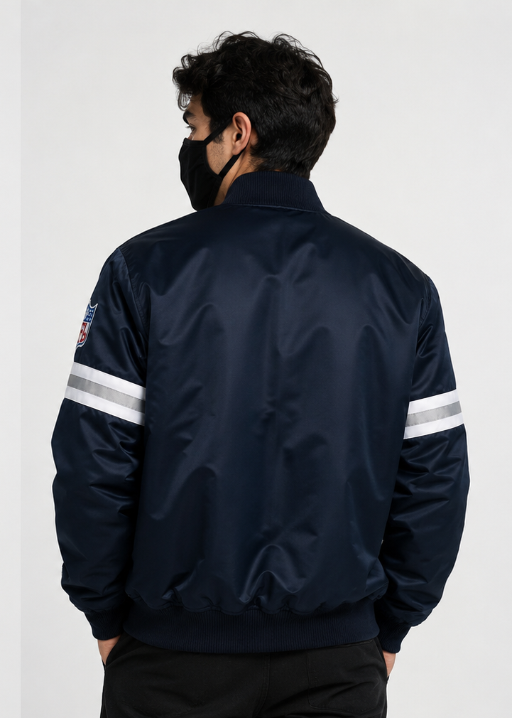 Person wearing a Dallas Cowboys navy bomber jacket with white stripes on the sleeves against a white background