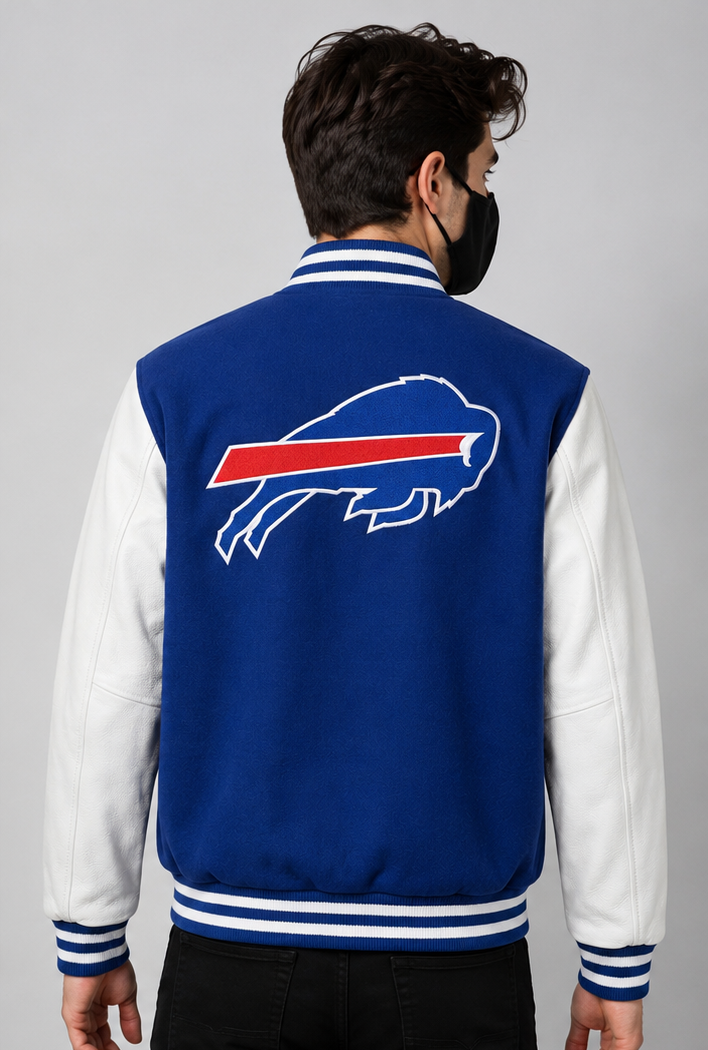A man viewed from the back wearing a royal blue and white varsity jacket with the Buffalo Bills embroidery logo on the back, set against a plain gray studio background.