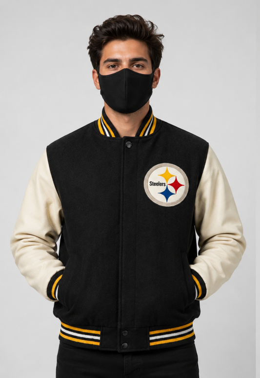 A man wearing a Pittsburgh Steelers varsity jacket with a black fleece body and cream sleeves, paired with a black face mask, against a light gray studio background.