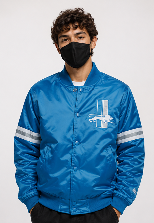 Person wearing a Detroit Lions blue jacket with a logo on a white background