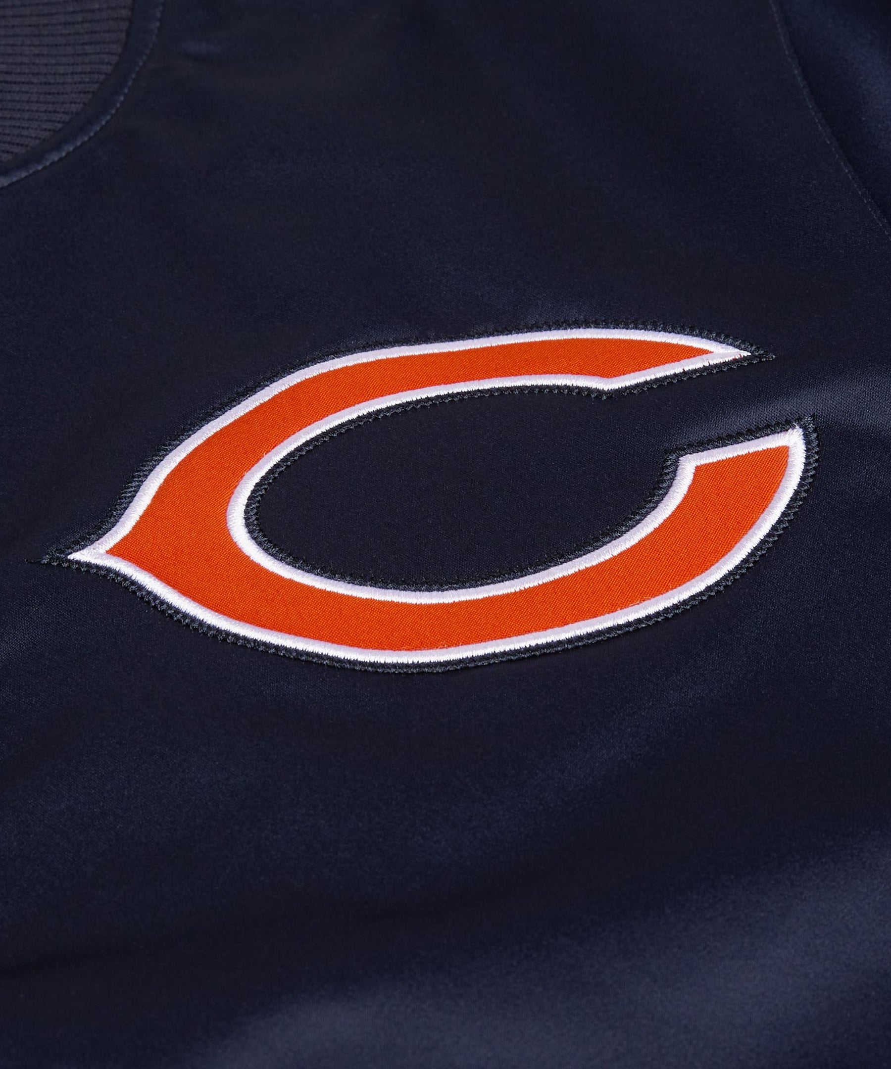 Close-up of a navy blue sports jersey with an orange and white logo.