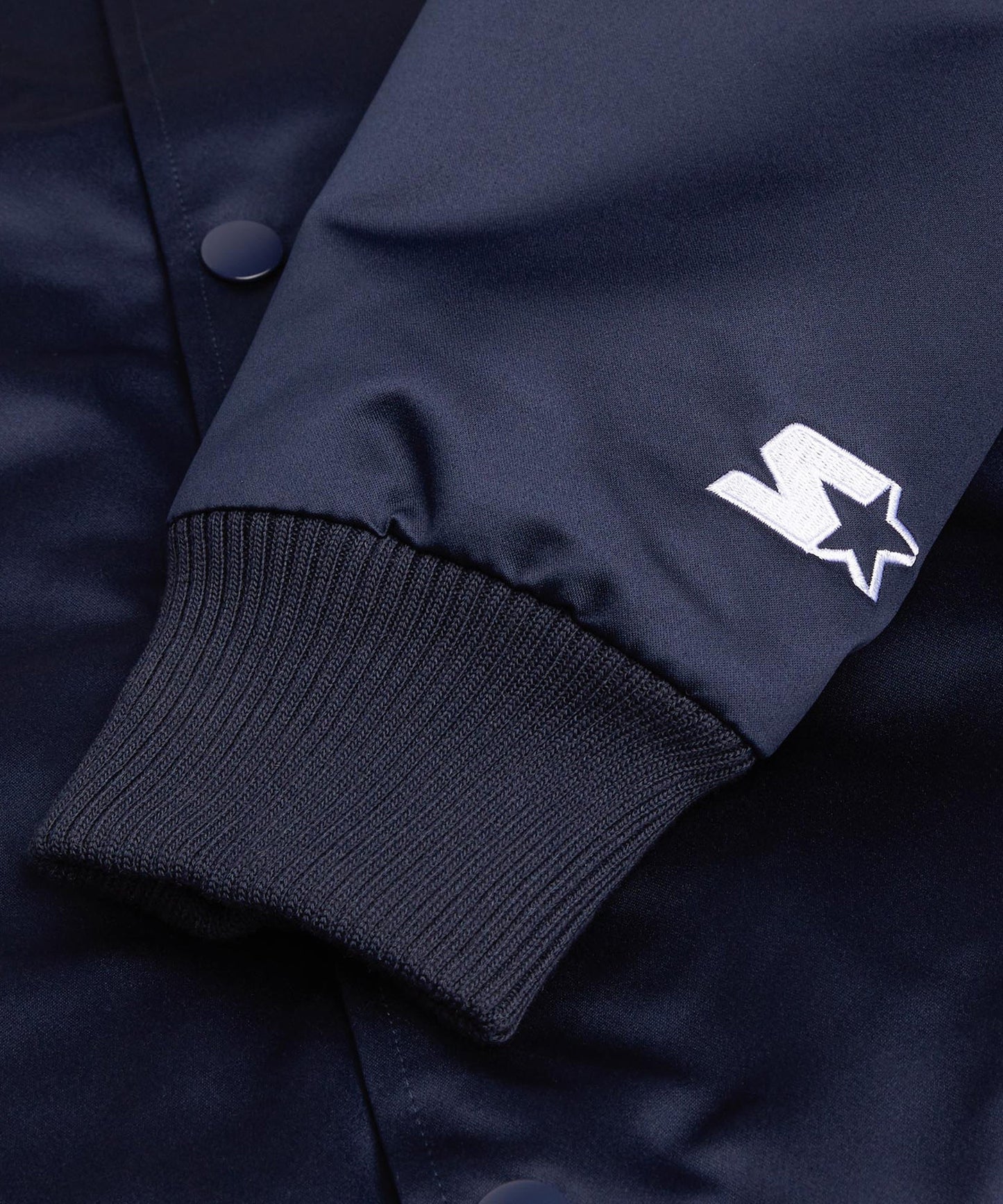 Navy blue jacket with a white logo on the sleeve