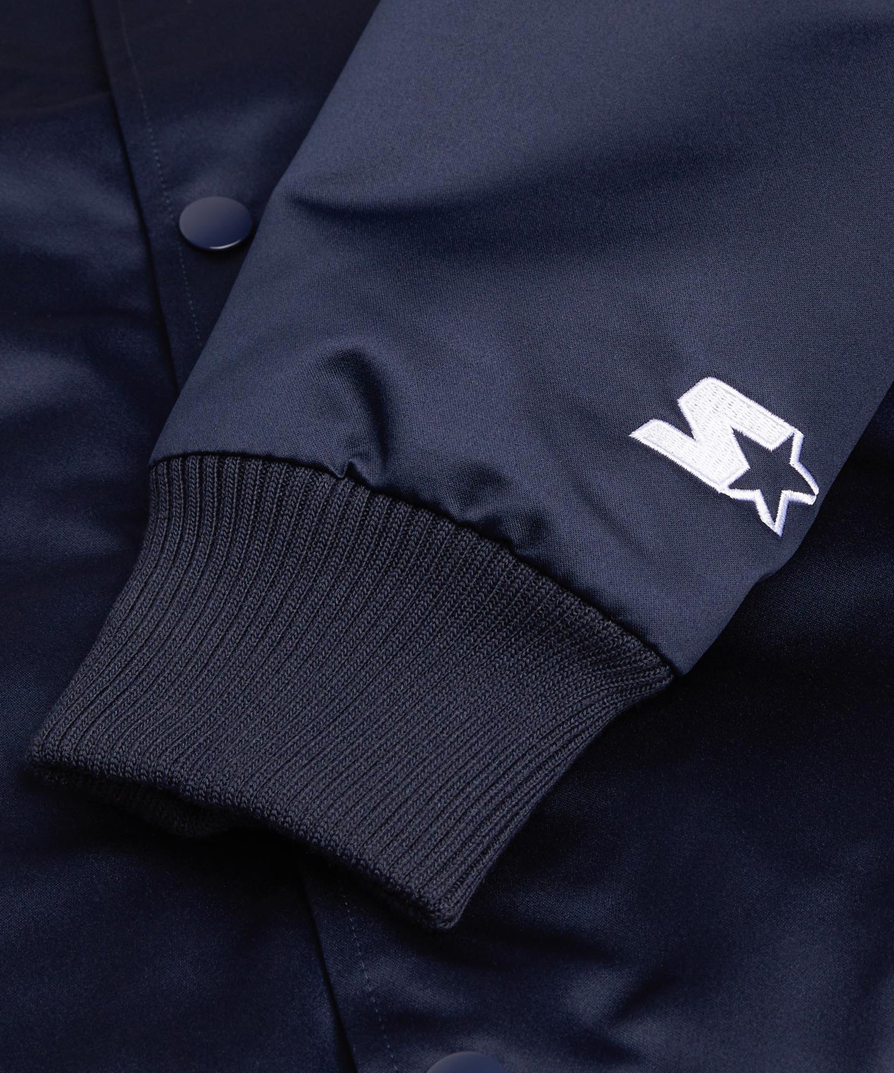 Navy blue jacket with a white logo on the sleeve