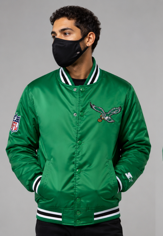 Person wearing a Philadelphia Eagles green jacket with a logo on a gray background