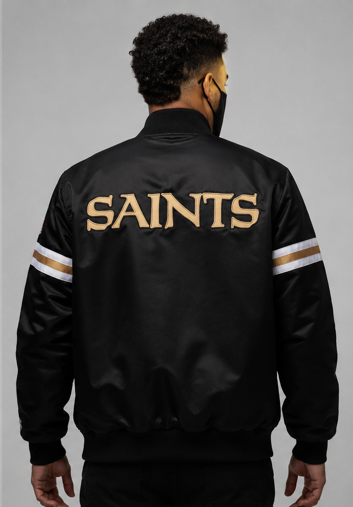 Person wearing a New Orleans Saints black jacket with 'SAINTS' printed on the back against a gray background
