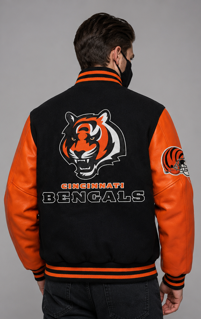 A man viewed from the back wearing a Cincinnati Bengals varsity jacket with a black body, orange sleeves, and a large embroidered tiger logo and team name on the back.
