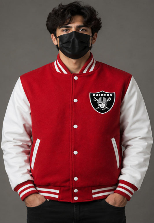A man wearing a red and white Oakland Raiders varsity jacket, featuring the team logo on the left chest, set against a solid gray studio background.