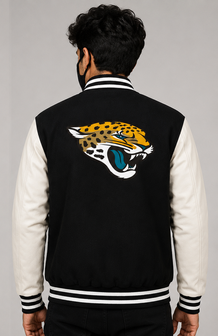 A man viewed from behind wearing a black and cream varsity jacket with a large embroidered Jacksonville Jaguars logo on the back.