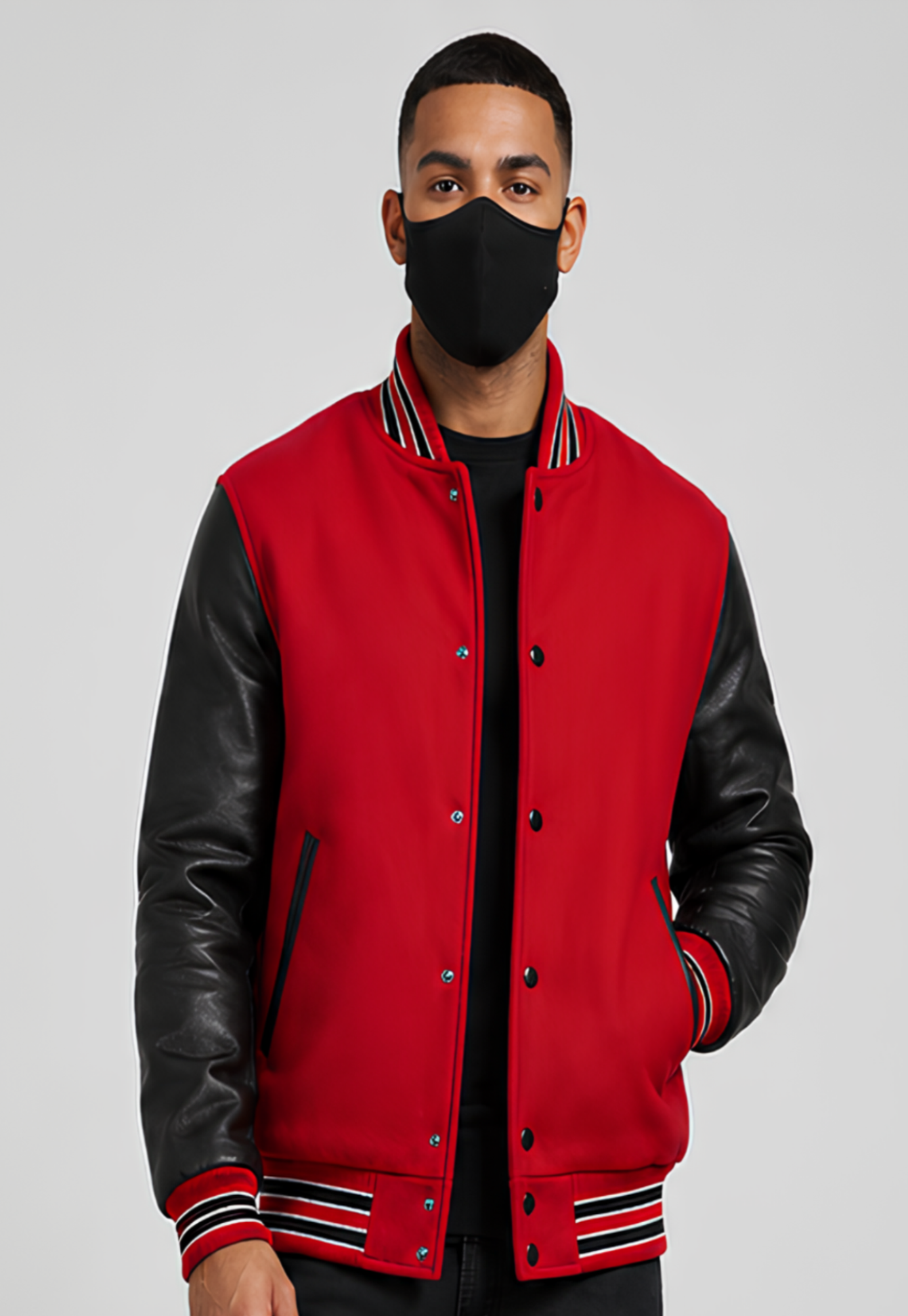 Person wearing a red varsity jacket with black leather sleeves on a gray background