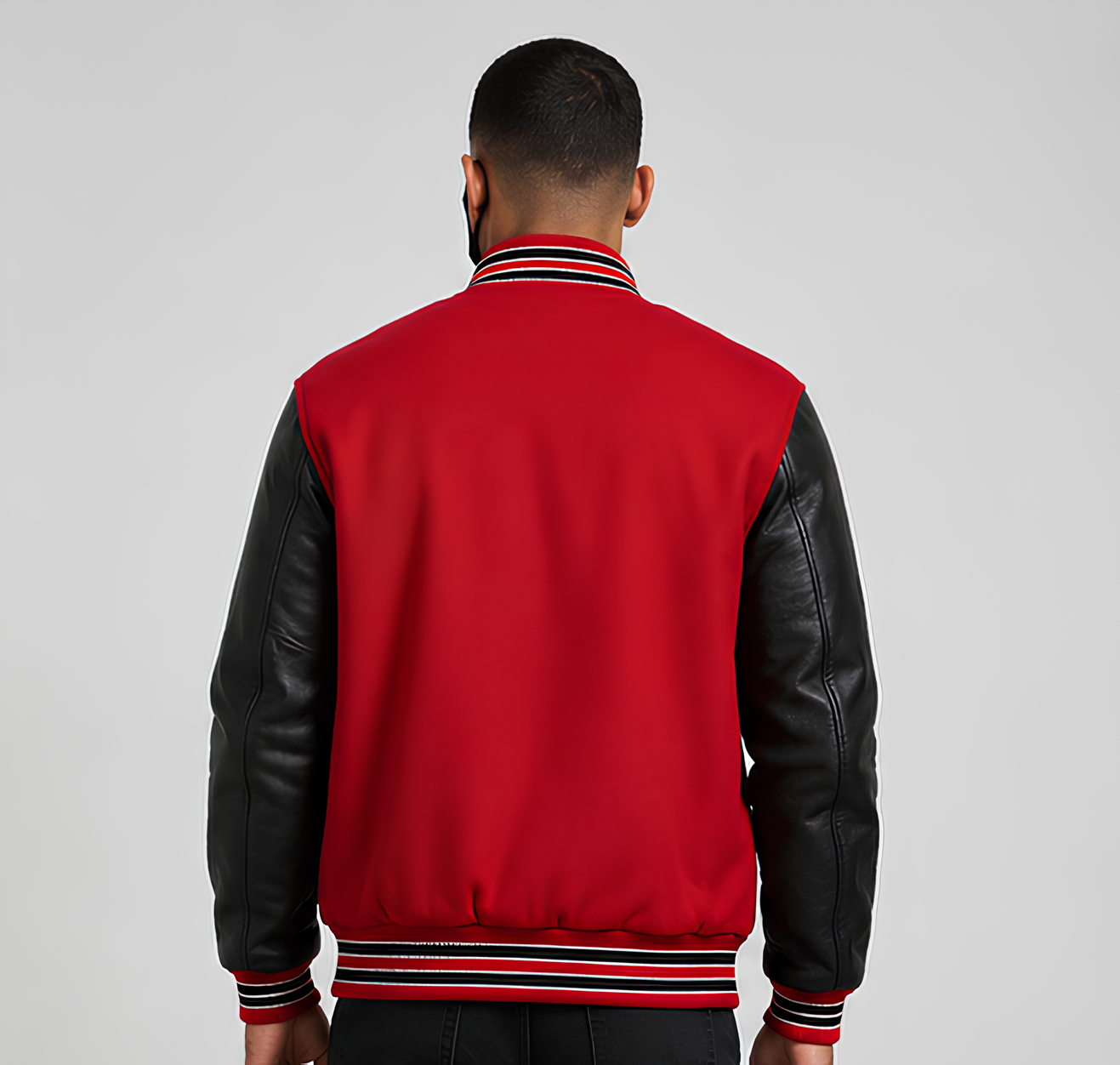 Person wearing a red and black varsity jacket on a gray background