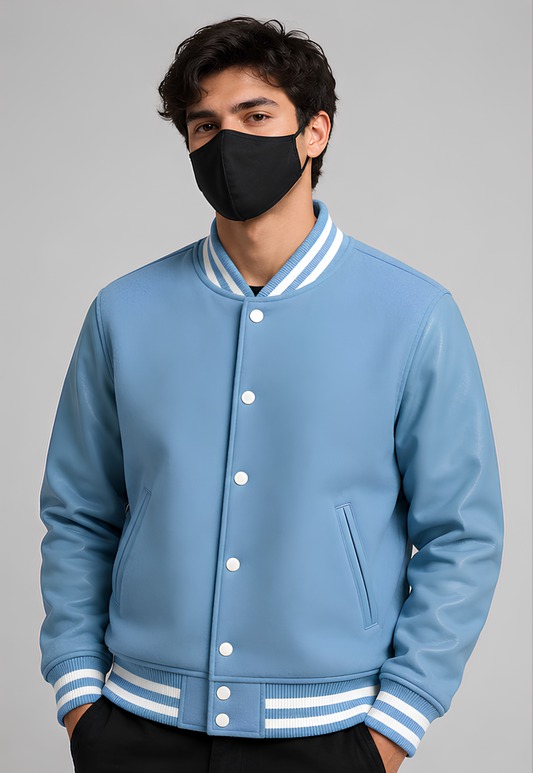 Person wearing a blue varsity jacket with white accents on a gray background