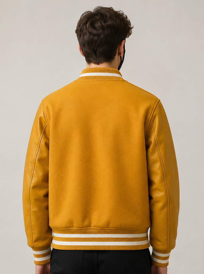 Person wearing a yellow varsity jacket with white stripes on a plain background