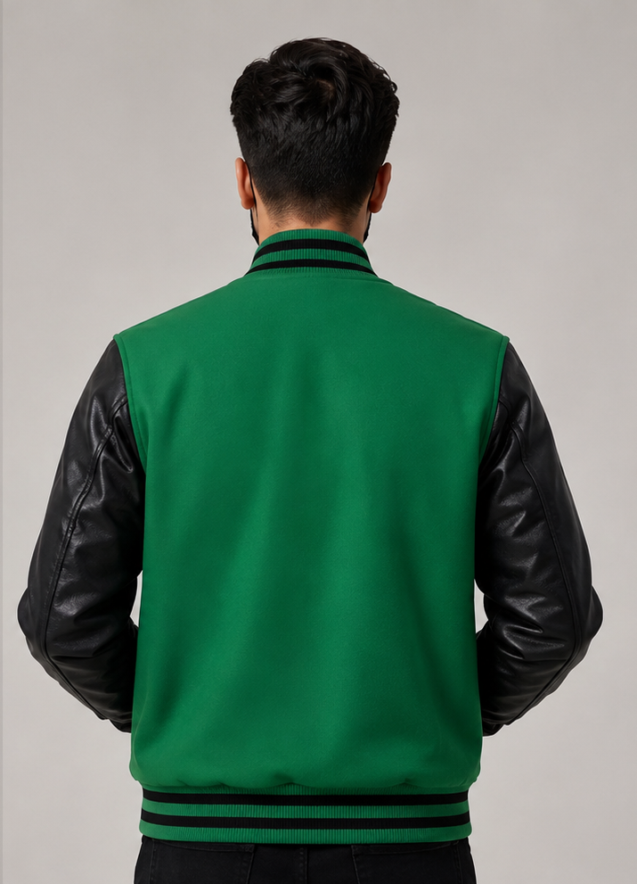 Man wearing a green varsity jacket with black leather sleeves on a gray background