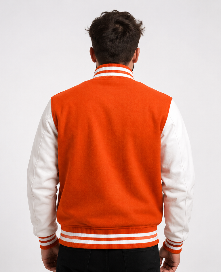 Person wearing an orange and white varsity jacket on a plain background